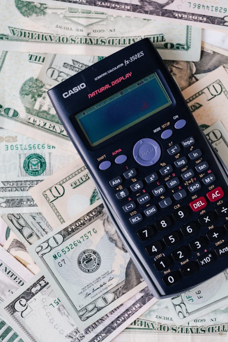 Electronic calculator on a stack of US dollar bills, representing budget planning and website cost calculations