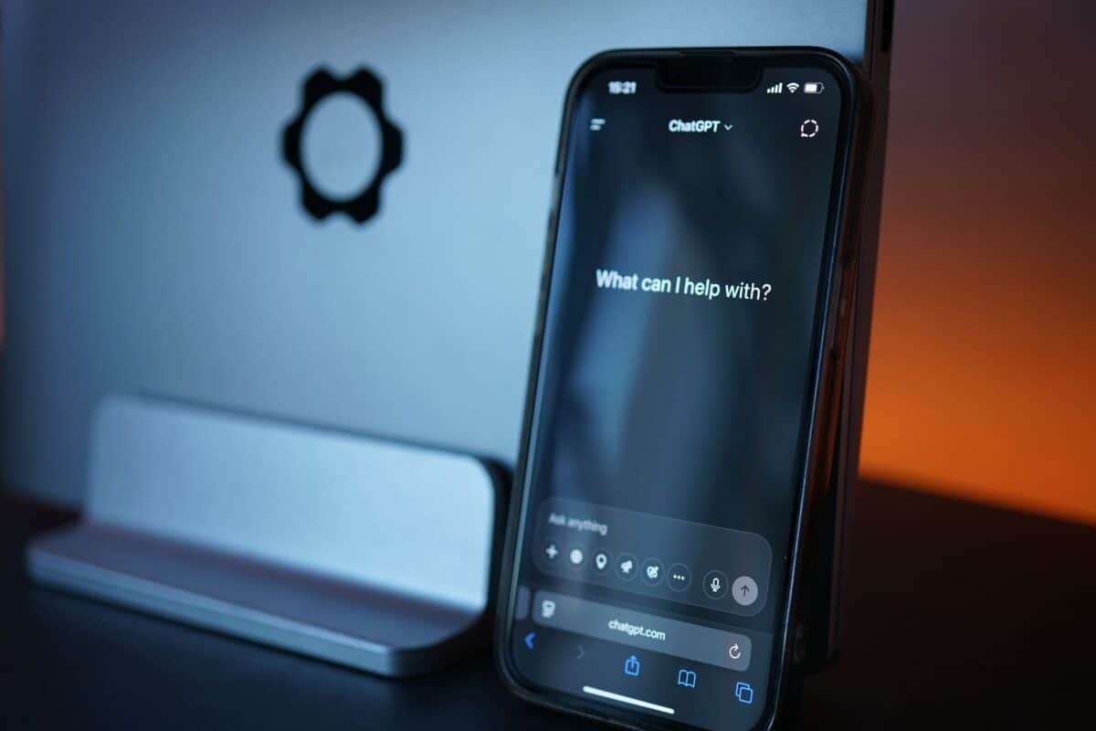 iPhone displaying ChatGPT app with 'What can I help with?' prompt