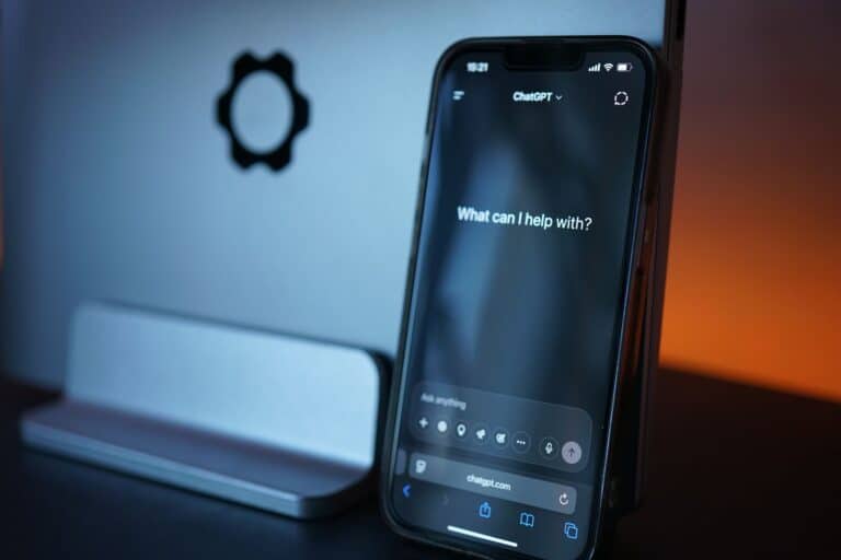 iPhone displaying ChatGPT app with 'What can I help with?' prompt