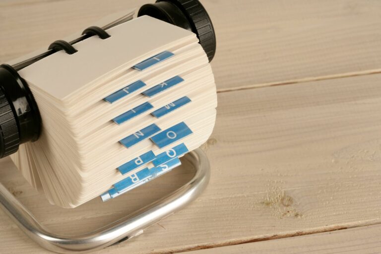 A vintage Rolodex card file with blue alphabet tabs on a wooden desk, illustrating how DNS acts as the internet's address book